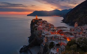 Aerial view of village on mountain cliff during orange sunset in Vernazza, Italy