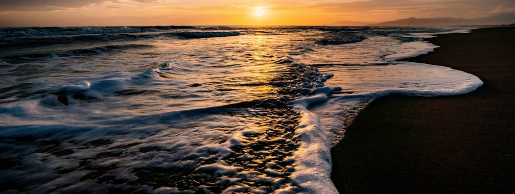 Amazing beach with waves and a sunset in Marina di Grosseto, Italy