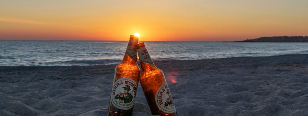 Two beer bottles at sunset in Toxic Beach, Rosignano, Italy